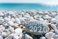 Stones on the beach with a blue sea and the inscription SUMMER 2020